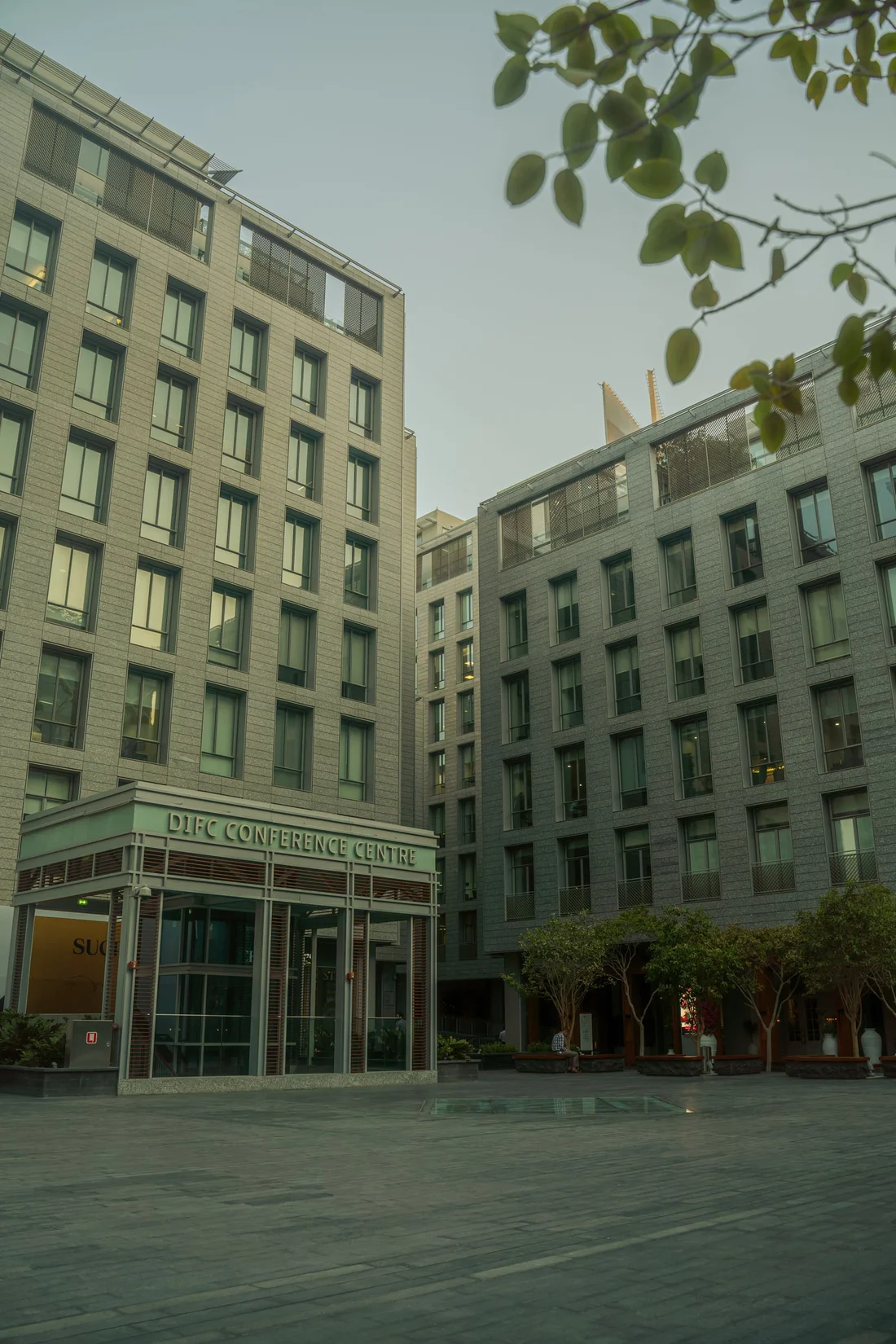 Real photograph of the stone and glass buildings around DIFC Conference Centre.
